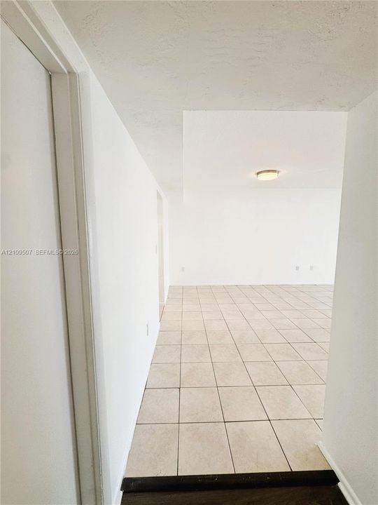 Neutral-toned tile flooring, recessed ceiling lighting, and crisp white wall finishes