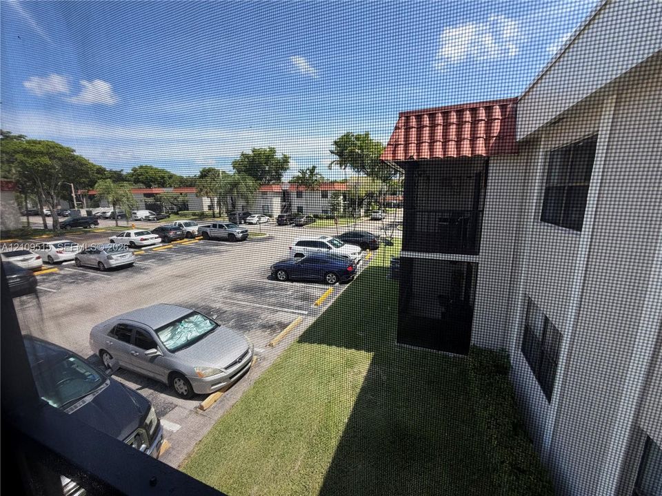 Multi-story exterior featuring a textured stucco facade, red clay roof tiles, and exterior corridors