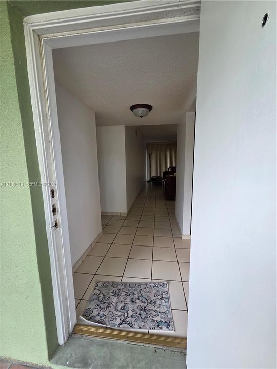 Interior area featuring neutral-toned tile flooring and vertical blinds