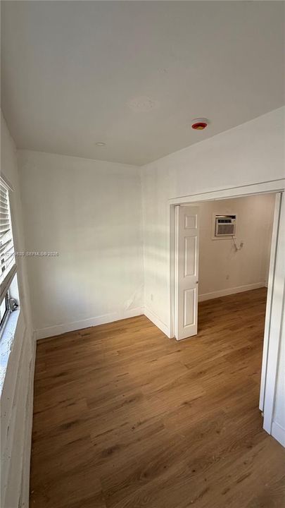 Room featuring wood-finish flooring, recessed lighting, and a multi-panel door