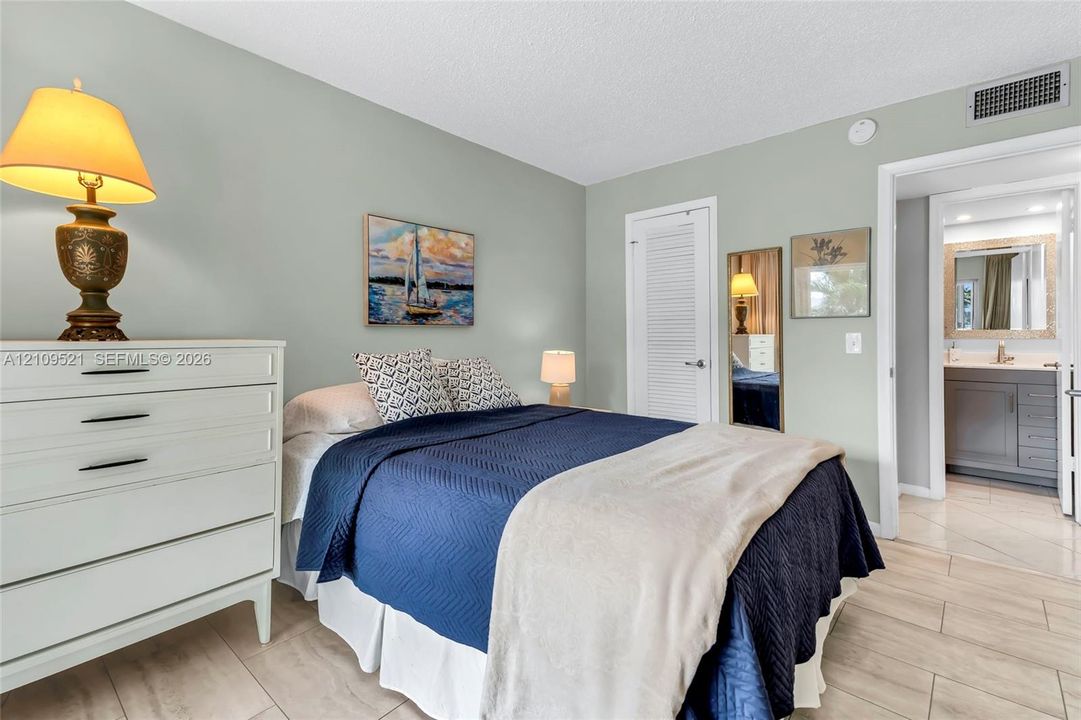 Neutral wall paint, light-toned tile flooring, and a louvered closet door