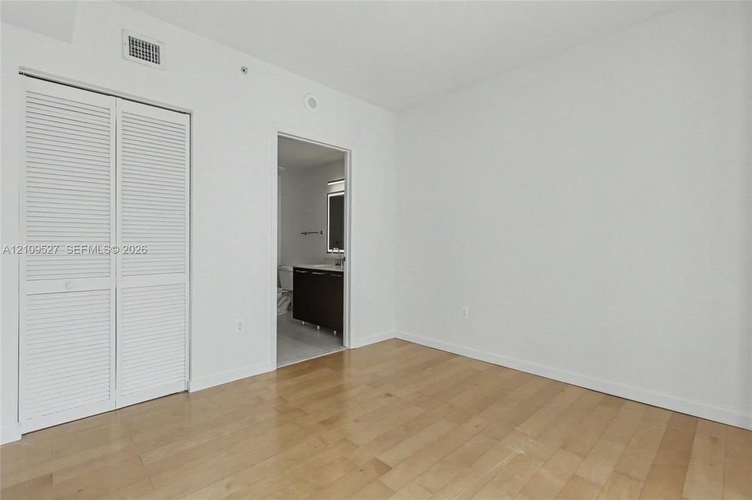 Interior space featuring wood-finish flooring and double louvered closet doors