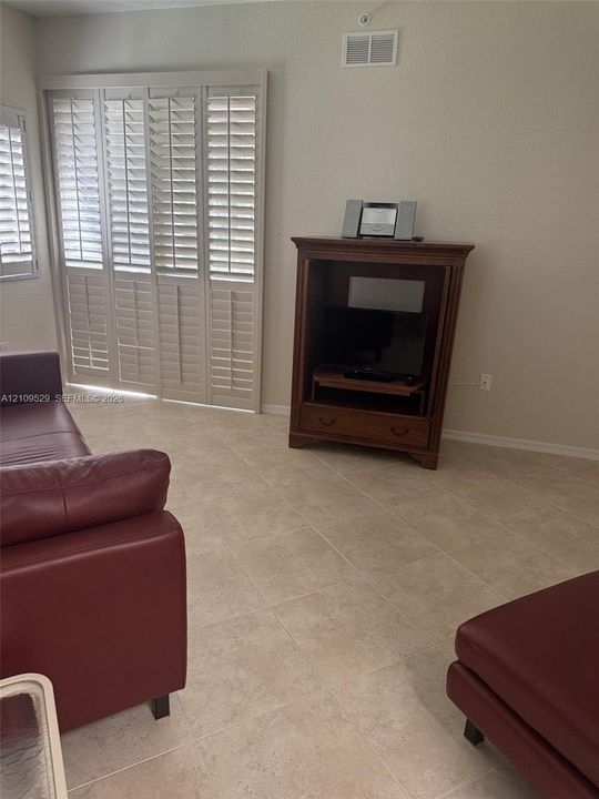 Interior space featuring ceramic tile flooring and floor-to-ceiling plantation shutters
