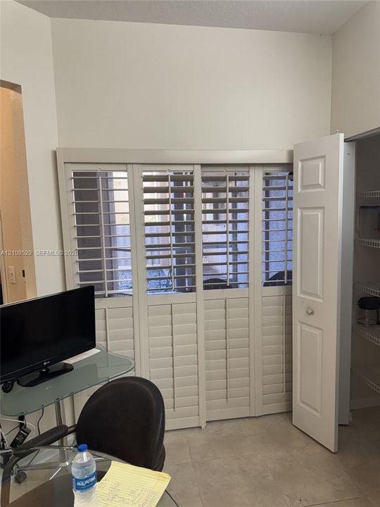 Off-white plantation shutters, bi-fold panel door, and built-in wire shelving