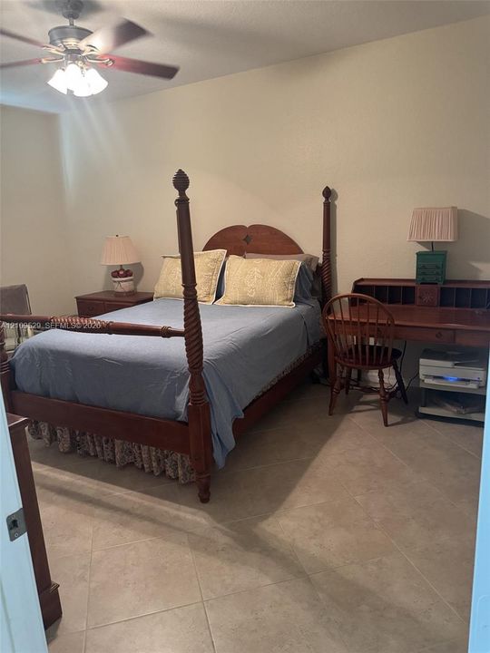 Neutral-toned ceramic tile flooring and ceiling-mounted light fixture with a multi-blade fan