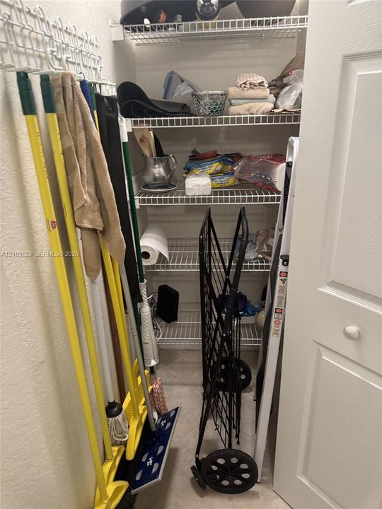 Storage closet featuring white wire shelving and a paneled door