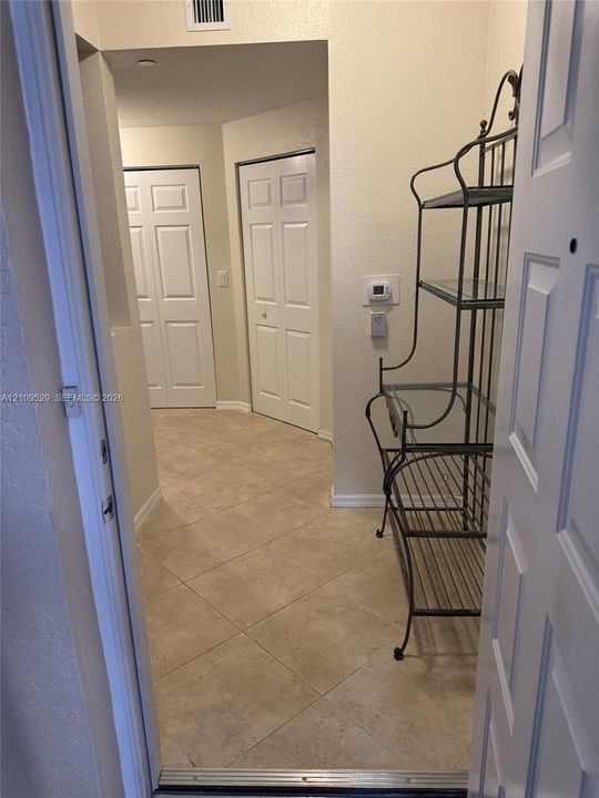 Neutral tile flooring with two white paneled closet doors