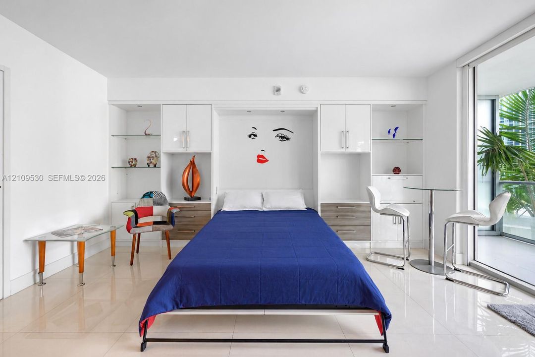 Built-in floor-to-ceiling cabinetry, high-gloss white upper cupboards, wood-finish lower drawers, recessed lighting, and large-format tile flooring