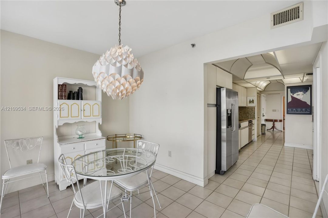 Ceramic tile flooring, stainless steel refrigerator, white built-in hutch, and decorative globe pendant light fixture