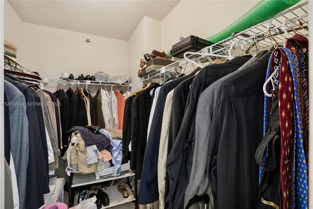 Walk-in storage space featuring dual-level wire shelving and integrated hanging rods
