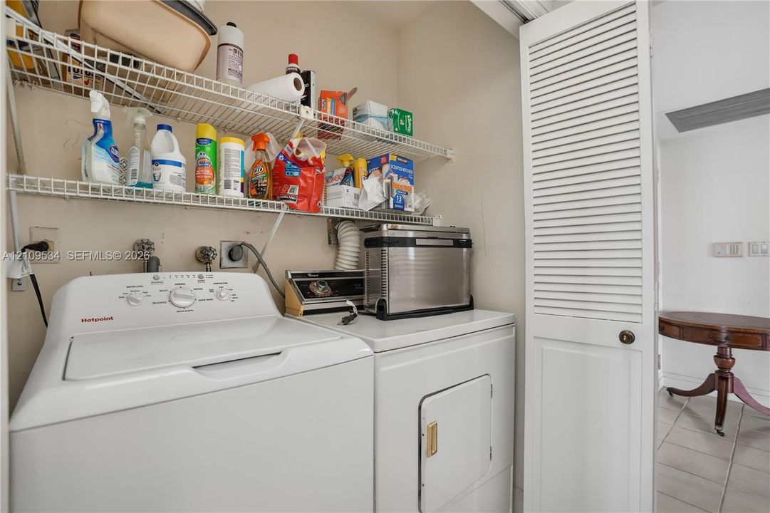 Laundry area featuring white louvered bifold doors and wire shelving