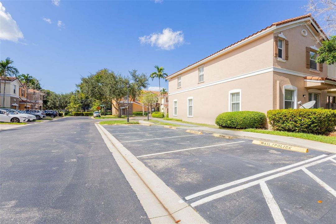 Stucco exterior building featuring a multi-pitched tile roof, multi-pane windows, and dedicated surface parking