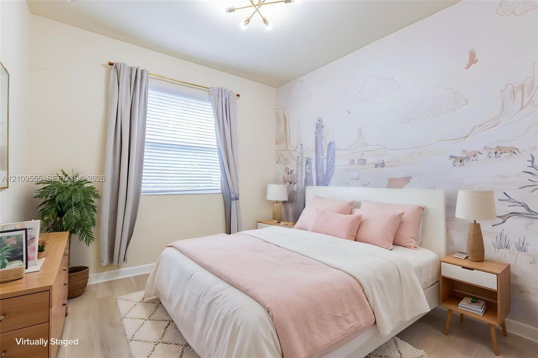 Room featuring wood-finish flooring, a decorative wall mural, and a multi-arm metallic ceiling fixture