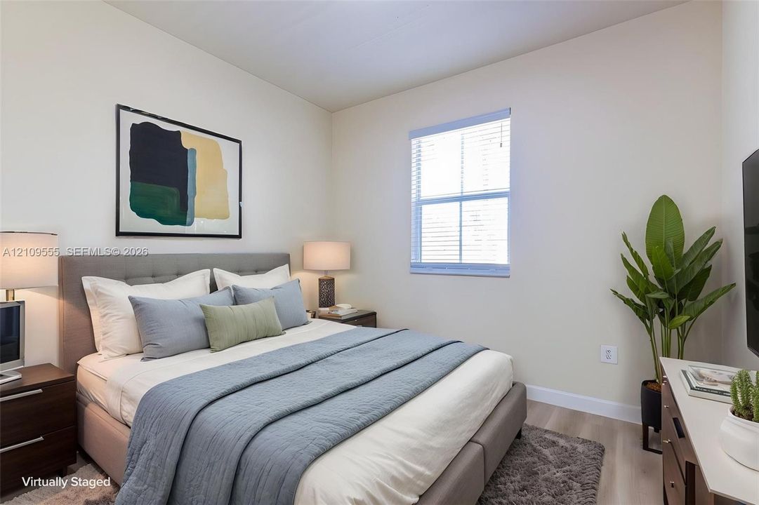 Neutral interior with wood-finish flooring and a single-hung window featuring horizontal blinds