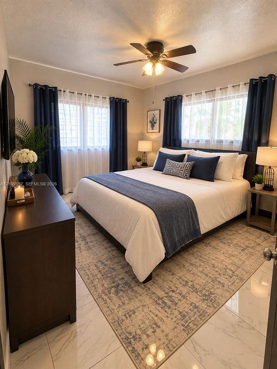 Bedroom featuring large-format tile flooring, a multi-blade ceiling fan with integrated lighting, and dual windows