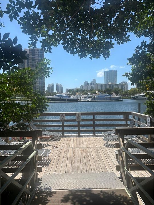 Waterfront wooden deck featuring perimeter railing and direct water access