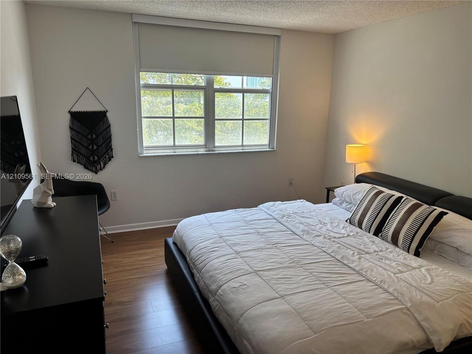 Wood-finish flooring and a multi-pane window with a roller shade