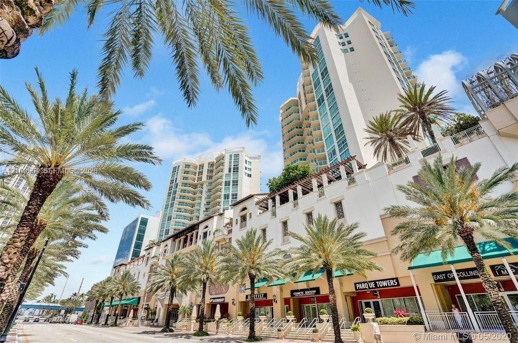 High-rise architectural exterior featuring multi-level balconies, ground-level retail storefronts with canvas awnings, and prominent palm tree landscaping