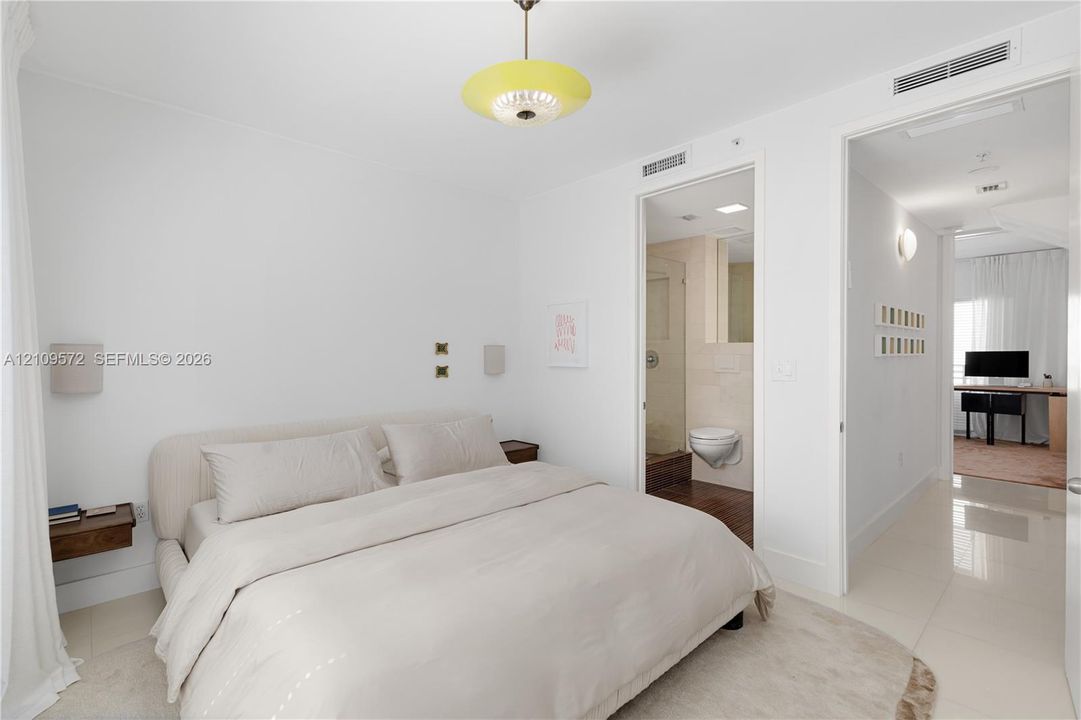 High-gloss tile flooring, wall-mounted wood-finish nightstands, recessed ceiling lighting, and a modern pendant light fixture