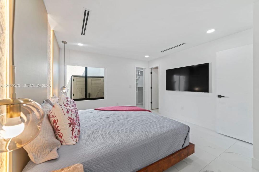 Recessed lighting, linear HVAC diffusers, stone-finish flooring, accent wall with integrated vertical lighting, and pendant illumination