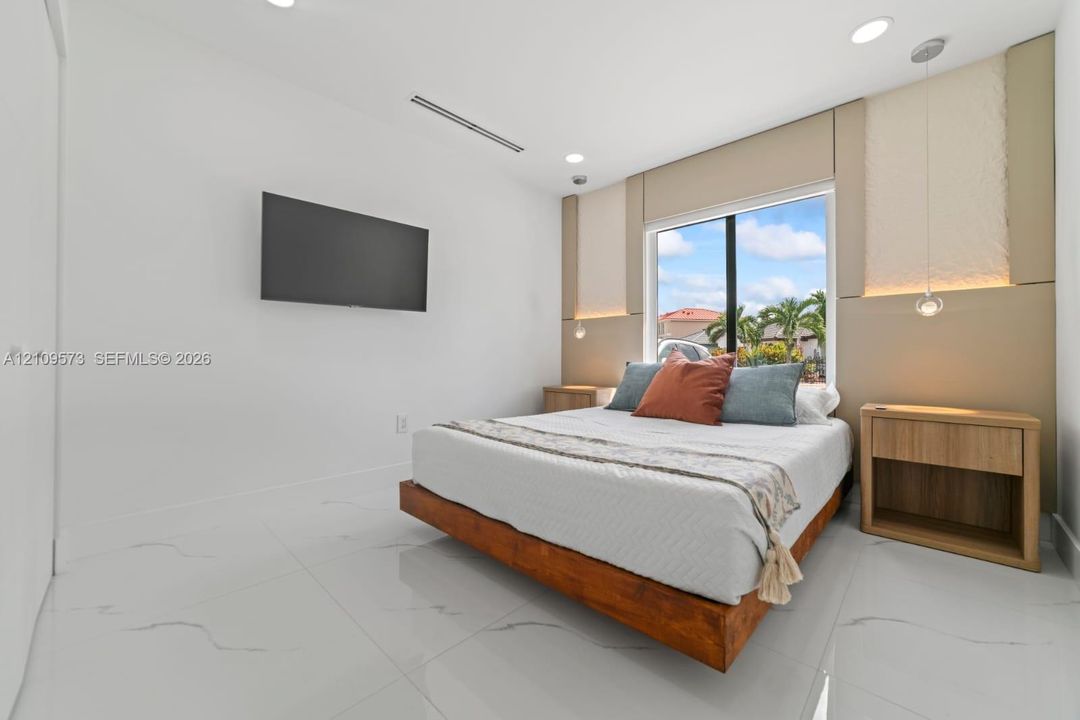 Polished stone-finish flooring, recessed ceiling lighting, wall-mounted light fixtures, and floor-to-ceiling decorative wall paneling
