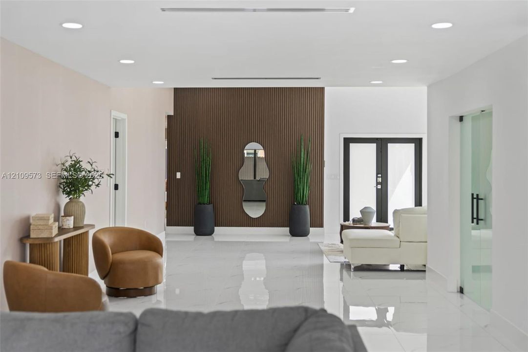 Polished tile flooring, recessed ceiling lighting, vertical wood-slat accent wall, and frosted glass paneled door