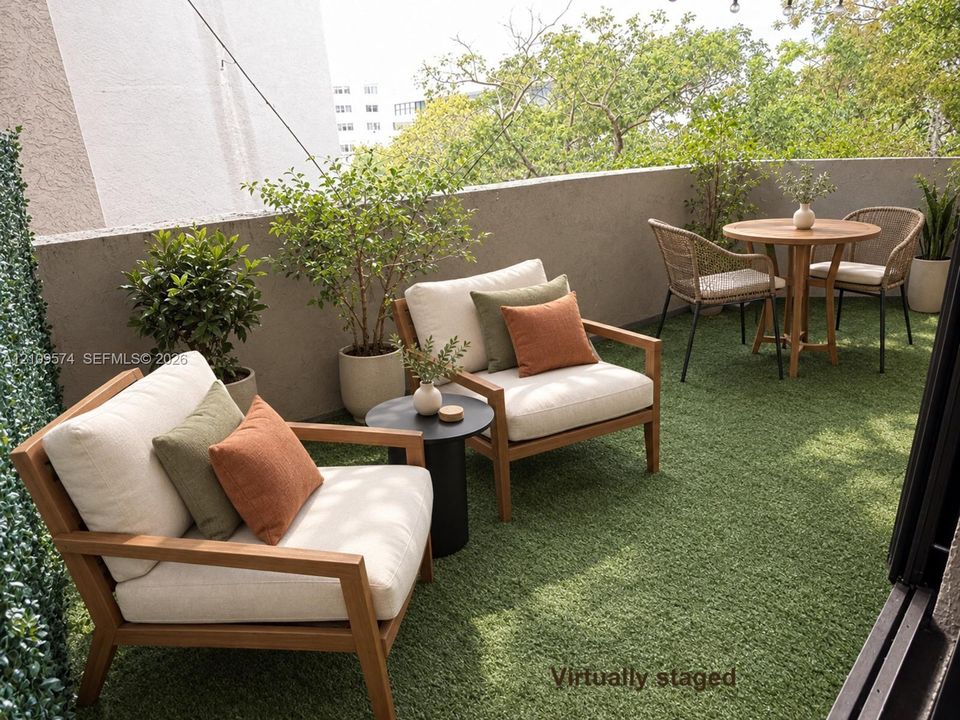 Staged Outdoor balcony featuring synthetic grass turf, solid concrete perimeter walls, and overhead string lighting