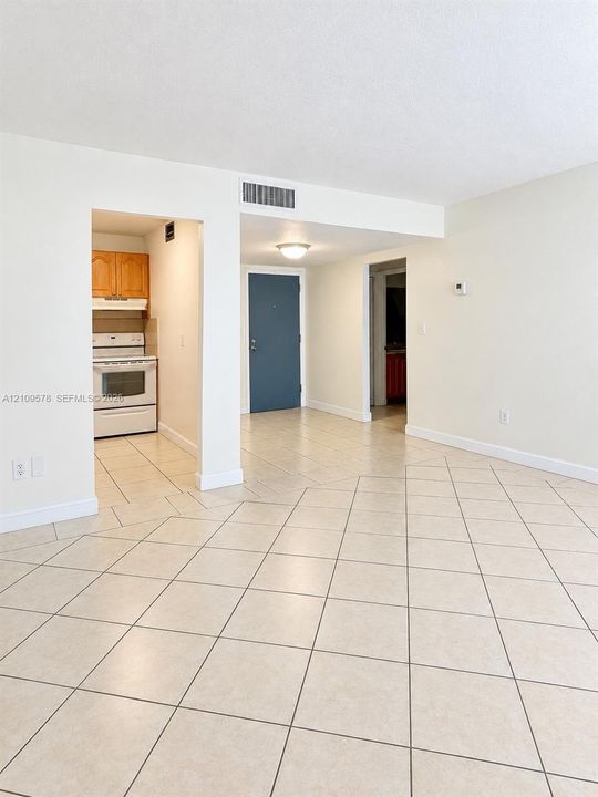 Ceramic tile flooring, kitchen featuring a white range, wood-finish cabinetry, and a flush-mount ceiling light