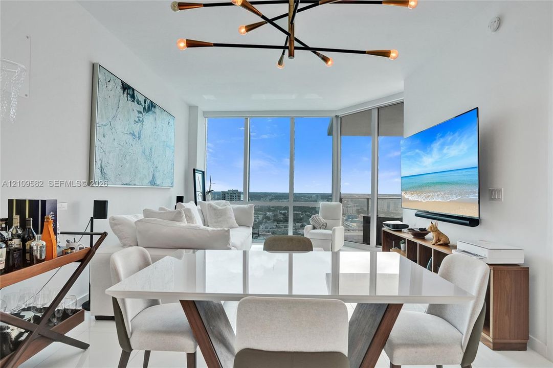 Floor-to-ceiling windows with expansive exterior exposure, modern multi-arm sputnik chandelier, and high-gloss flooring