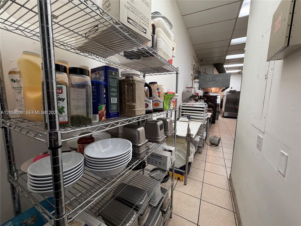 Commercial storage area featuring multi-tier industrial wire shelving, drop ceiling with recessed lighting, and ceramic tile flooring