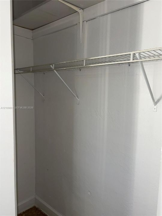 Closet featuring upper and lower wire shelving with structural support brackets