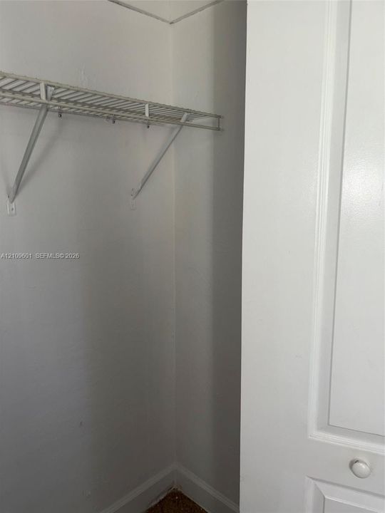 2nd' bedroom closet featuring a white-painted door with a round knob and a built-in wire storage shelf