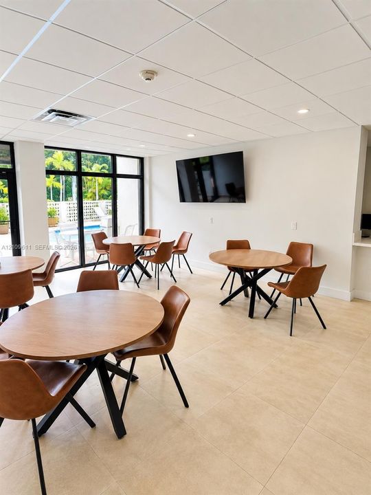 Common area featuring large format tile flooring, a suspended acoustic ceiling with recessed lighting, and floor-to-ceiling glass windows