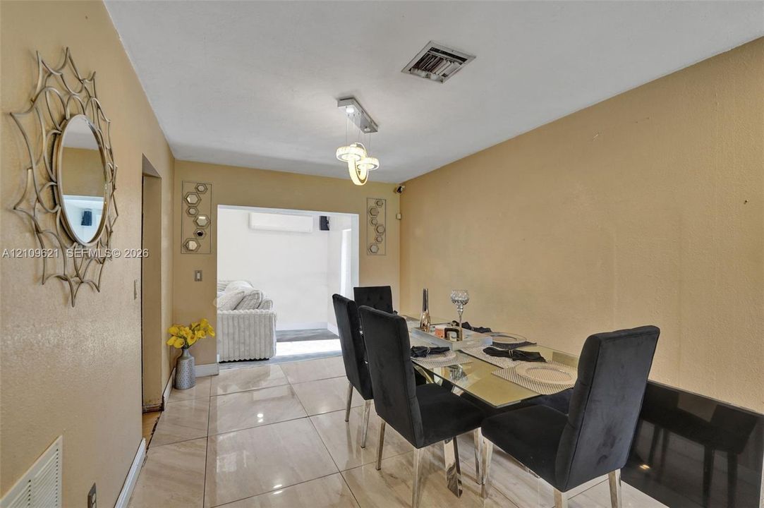 Interior space featuring large-format tile flooring and a modern multi-light chandelier fixture