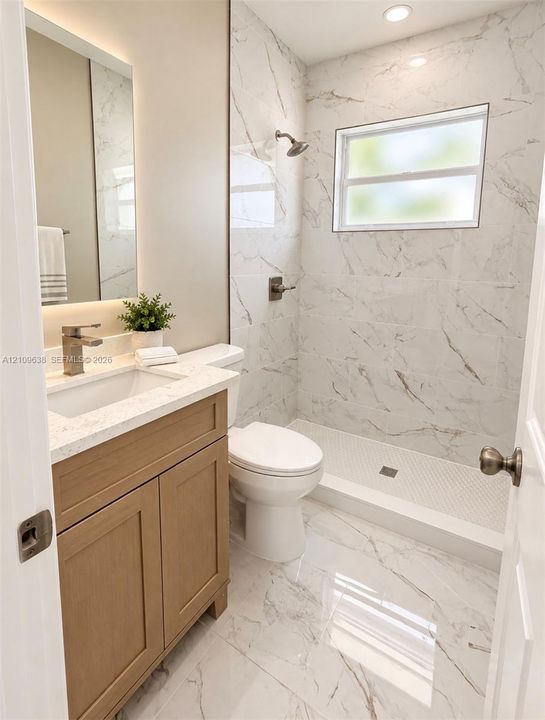 Bathroom featuring a wood-finish vanity with a stone-composite countertop, full-height tile shower surround, integrated backlighting, and tile flooring