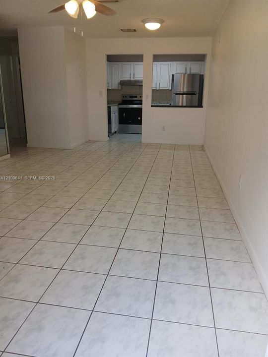 Ceramic tile flooring, white cabinetry, and stainless steel kitchen appliances, including a range and refrigerator