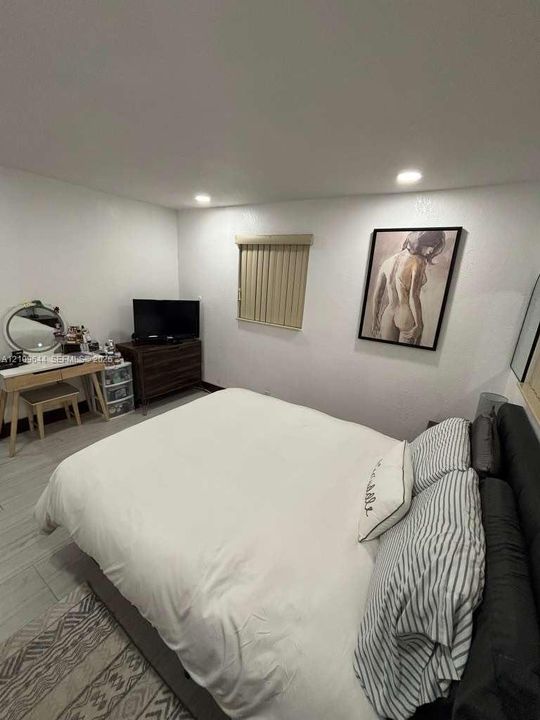 Neutral-toned walls, recessed lighting, and wood-finish tile flooring