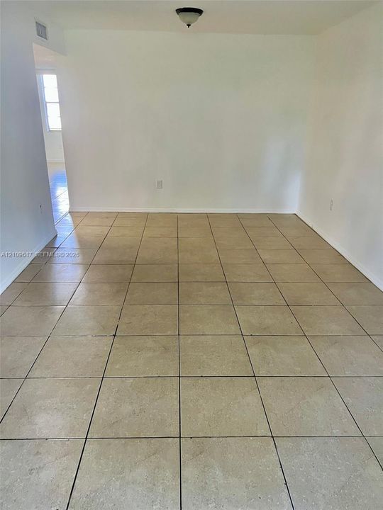 Interior space featuring neutral wall tones, large-format ceramic tile flooring, and a flush-mount overhead light fixture