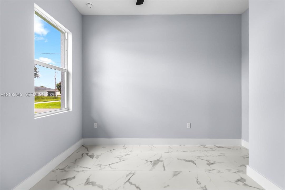 Interior space featuring large-format tile flooring with a marble-finish pattern, light-toned wall paint, and a single-hung window
