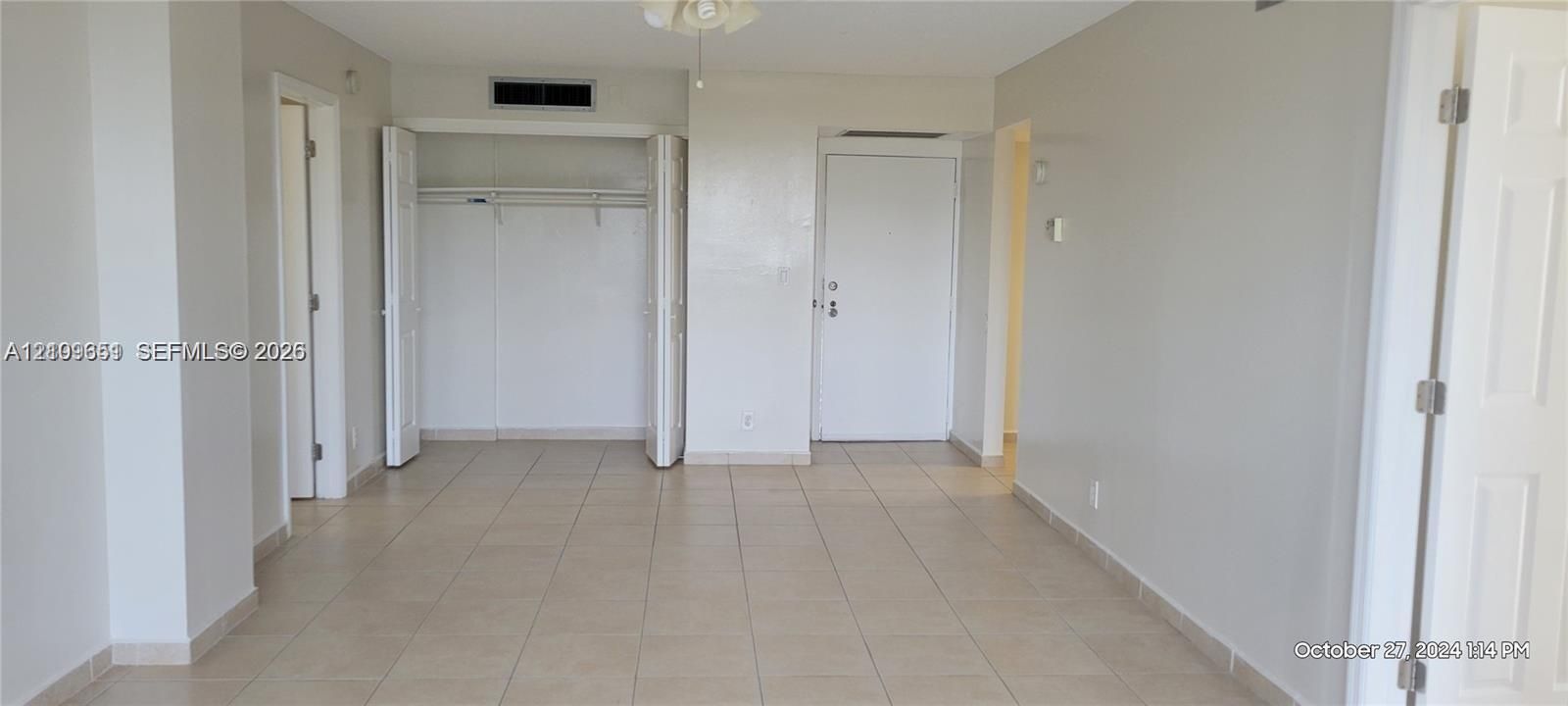 Neutral-toned interior featuring ceramic tile flooring, a closet with bi-fold doors, and a ceiling-mounted light fixture