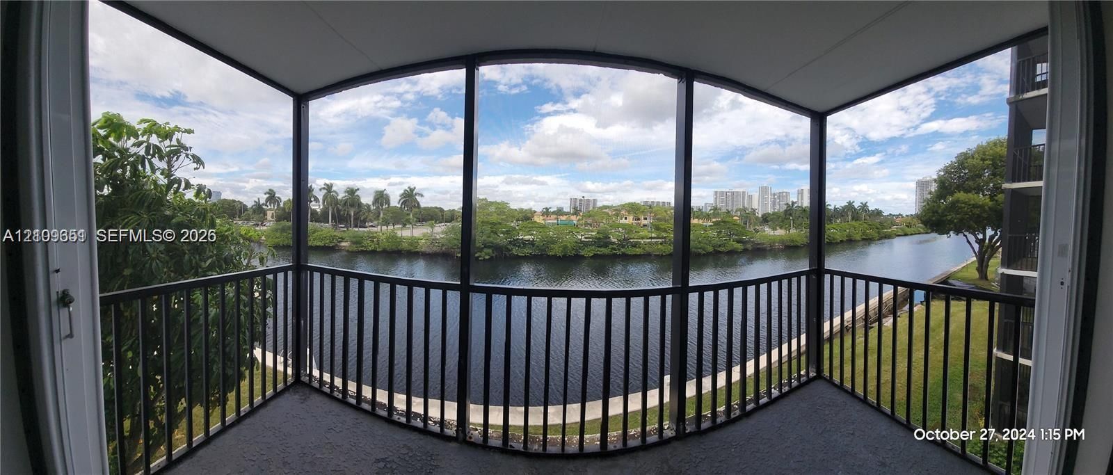 Screened-in balcony featuring black metal railings and overhead canopy coverage