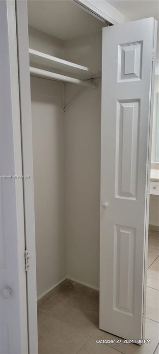 Closet featuring a three-panel door and an integrated upper shelving rod