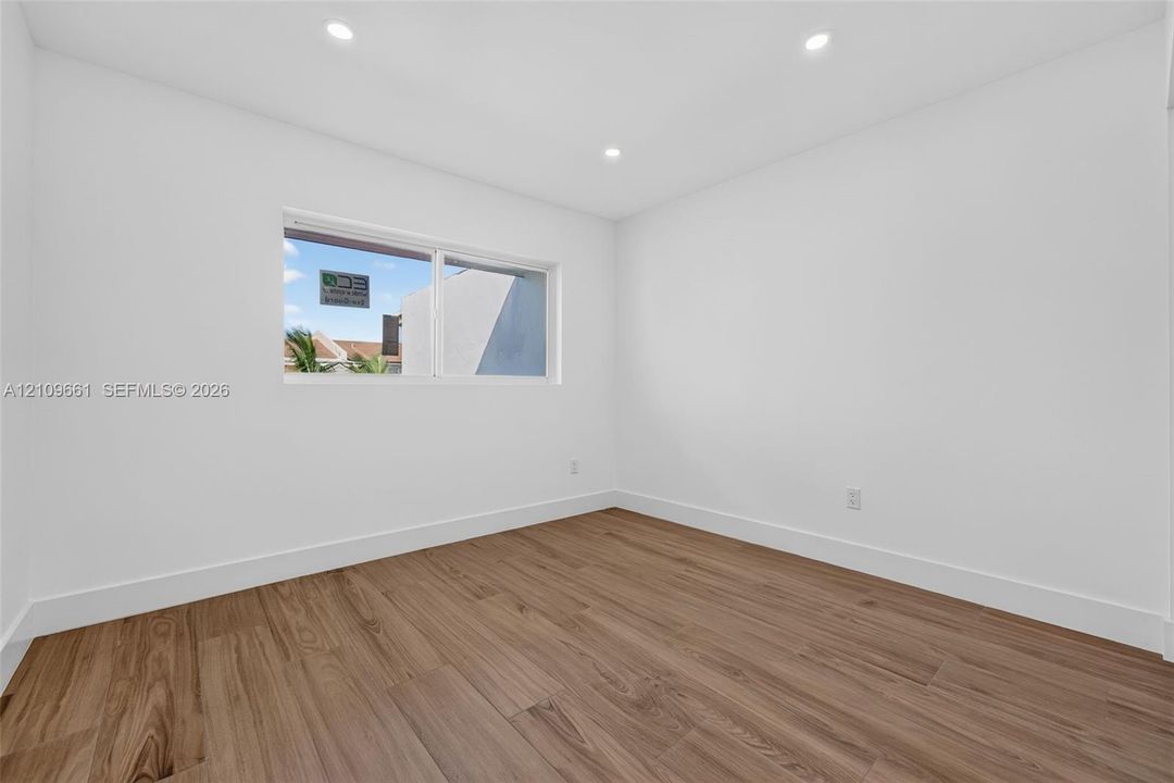 Interior space featuring wood-finish flooring, recessed lighting, and a large horizontal sliding window
