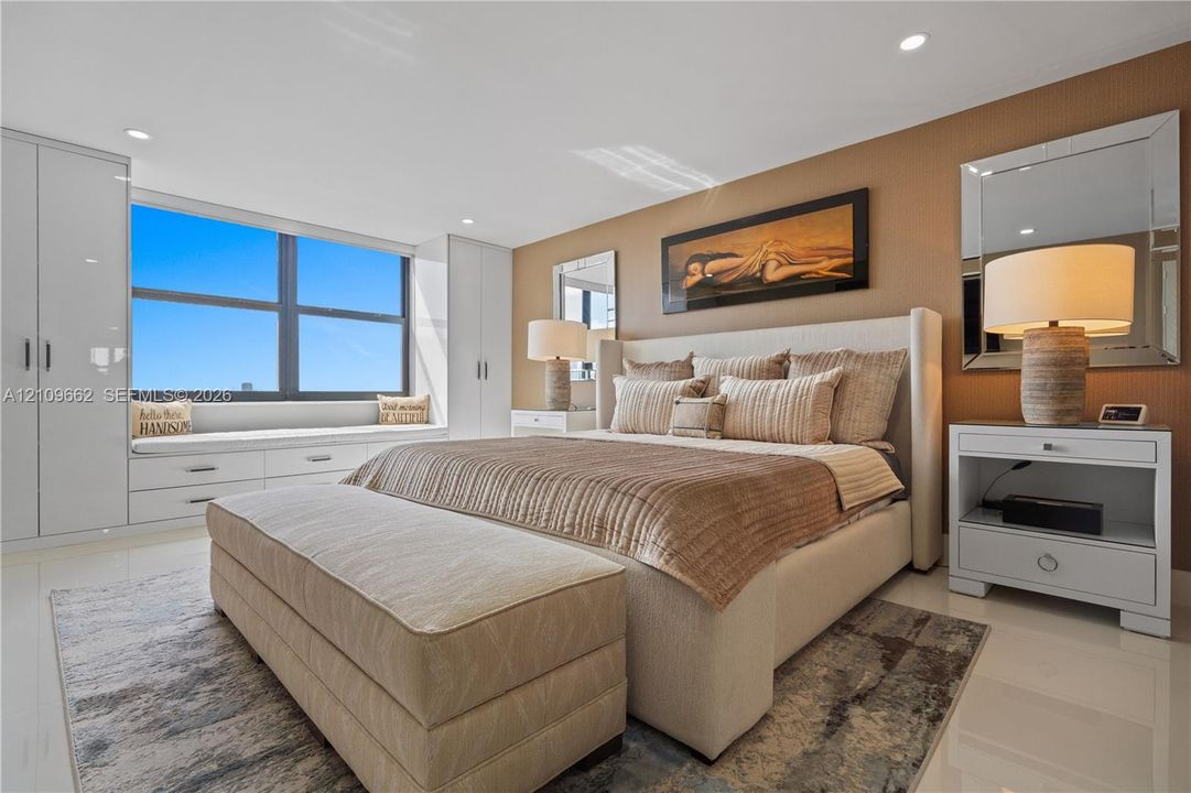 Spacious interior featuring high-gloss flooring, large picture window with built-in cabinetry, and full-height wardrobe storage