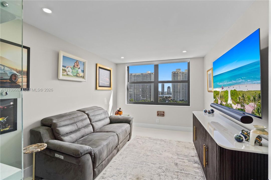 Large-format window, recessed lighting, and neutral-toned wall paint