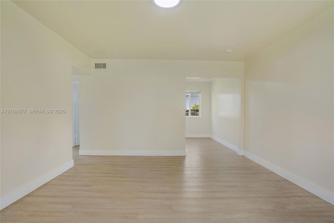 Neutral interior featuring wood-finish flooring, smooth wall surfaces, and a ceiling-mounted light fixture