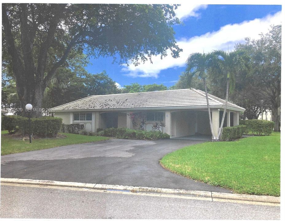 Single-story exterior featuring a gabled roofline, covered entryway, manicured lawn, paved driveway, and mature landscaping
