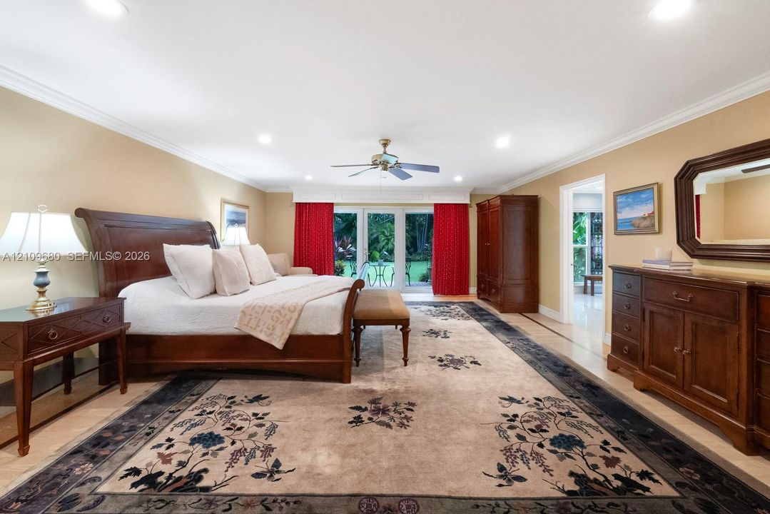 Spacious room featuring crown molding, recessed lighting, polished stone flooring, and French doors