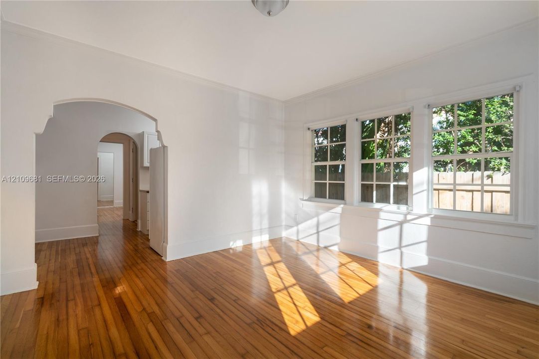 Wood-finish flooring, multi-pane windows, and architectural arched doorways