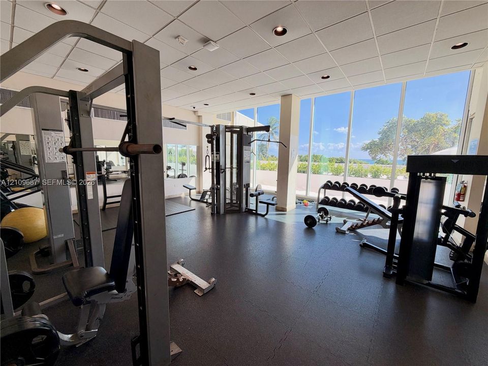 Fitness center featuring floor-to-ceiling windows, rubberized flooring, and recessed ceiling lighting